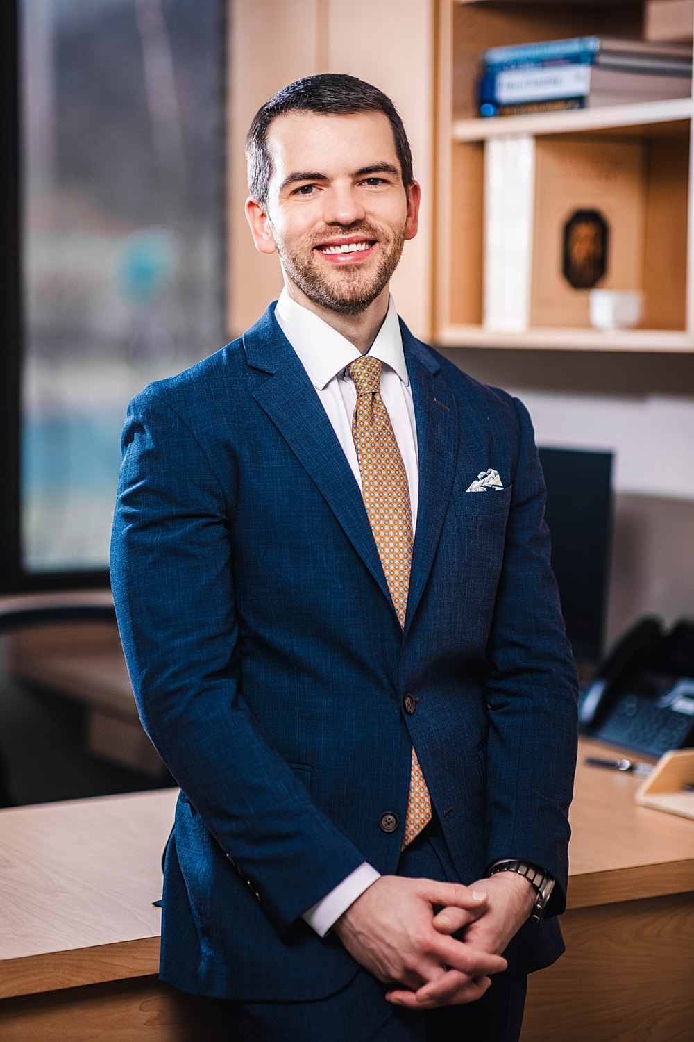 Professional man in a blue suit smiling.