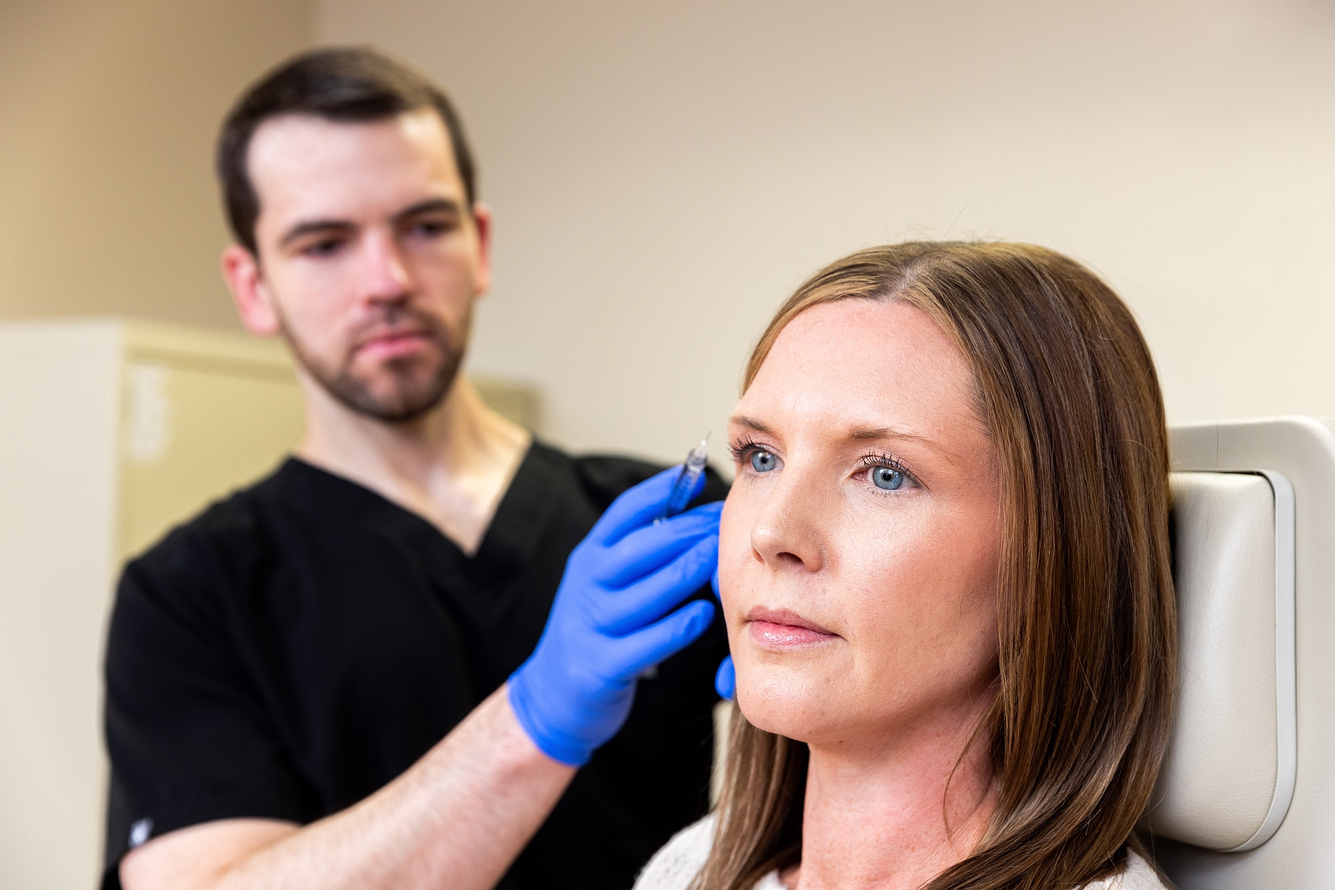 Medical professional administering cosmetic treatment to patient.